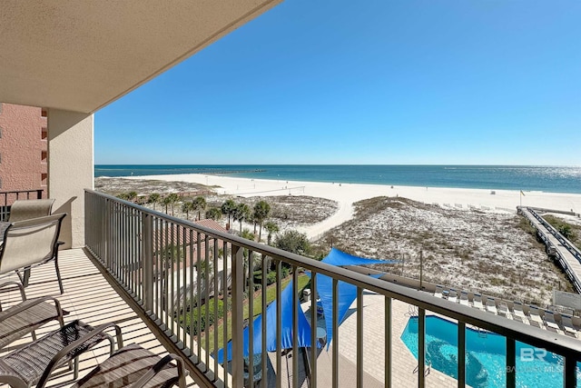 balcony featuring a water view and a beach view