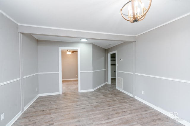 unfurnished room with ceiling fan with notable chandelier, light wood-type flooring, and crown molding