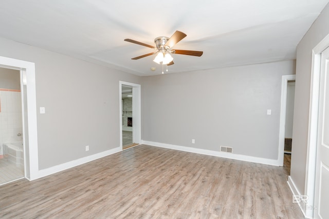 unfurnished bedroom with ceiling fan, light wood-type flooring, and ensuite bath