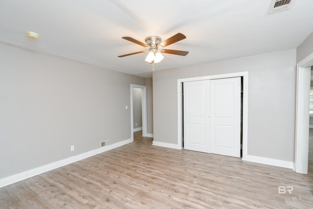 unfurnished bedroom featuring a closet, light hardwood / wood-style flooring, and ceiling fan