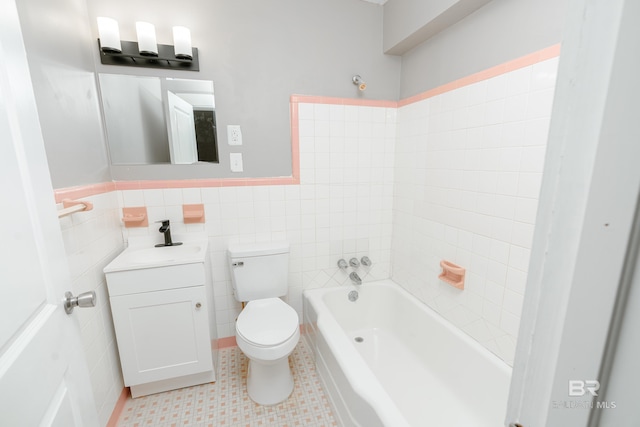 bathroom featuring tile patterned floors, vanity, toilet, and tile walls