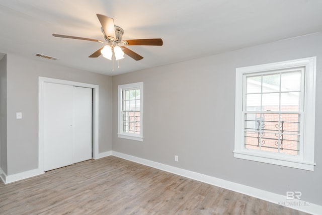 unfurnished bedroom featuring ceiling fan, light hardwood / wood-style floors, and a closet