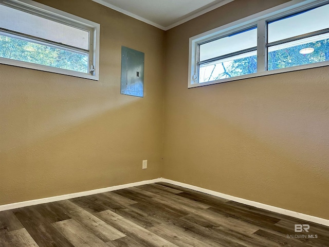 unfurnished room featuring electric panel, crown molding, and hardwood / wood-style flooring