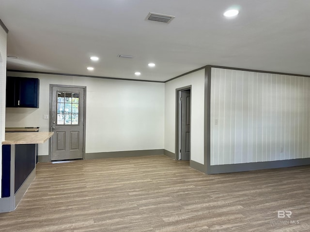 interior space featuring crown molding and light hardwood / wood-style flooring