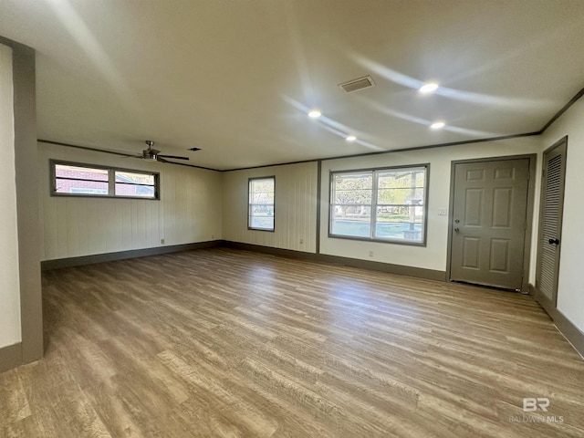 spare room featuring ceiling fan, a healthy amount of sunlight, and light hardwood / wood-style floors