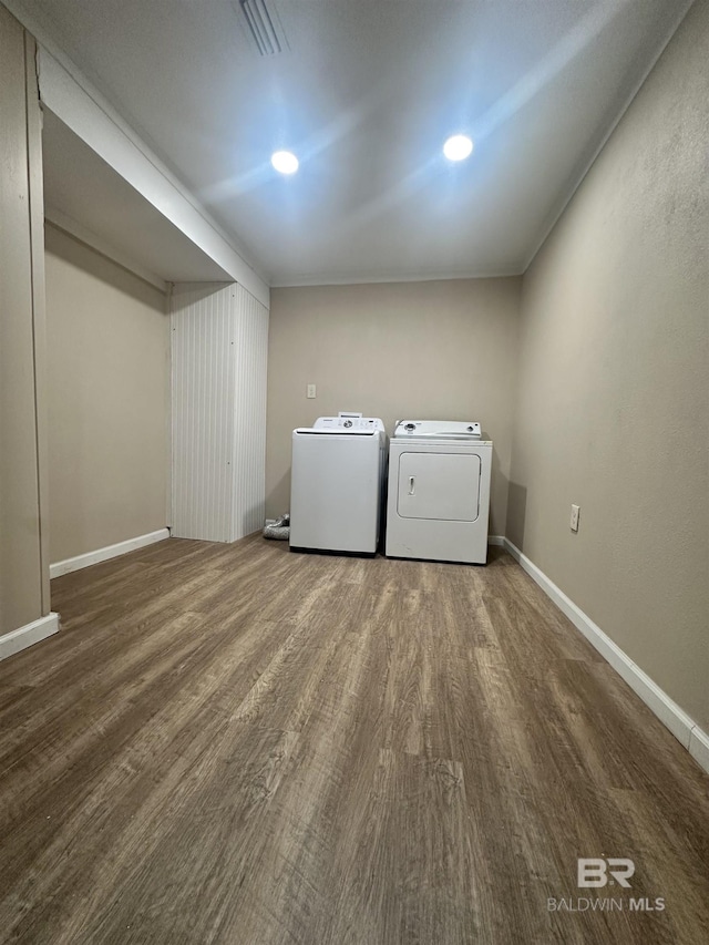 clothes washing area with independent washer and dryer and hardwood / wood-style flooring