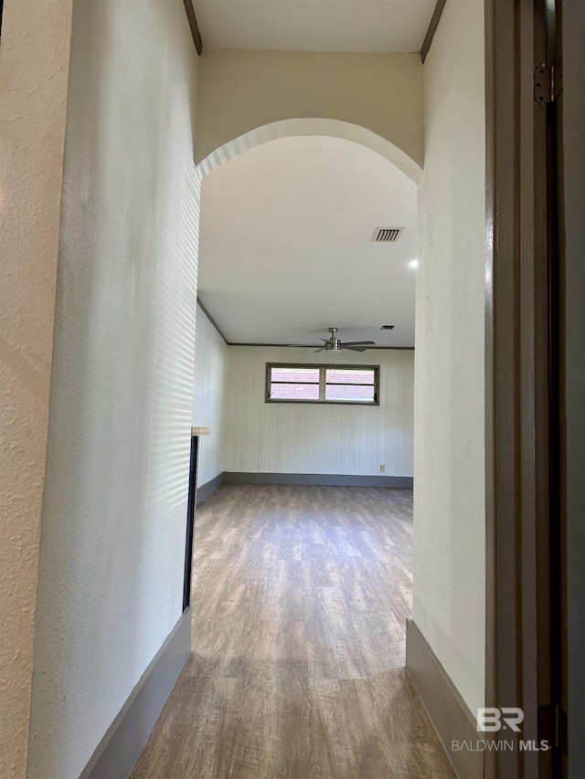 hallway featuring hardwood / wood-style floors and wood walls