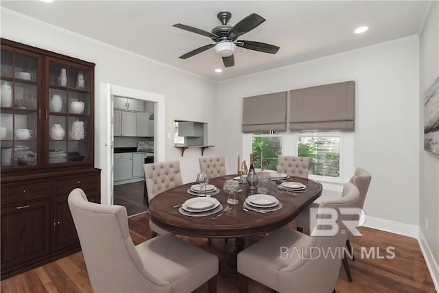 dining area featuring ceiling fan, dark wood-type flooring, and ornamental molding