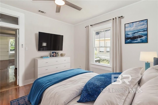 bedroom with ceiling fan, wood-type flooring, and ornamental molding