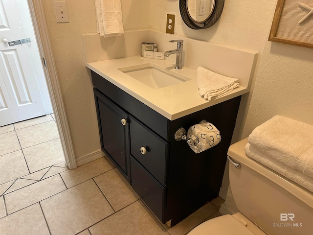 bathroom featuring tile flooring, toilet, and vanity