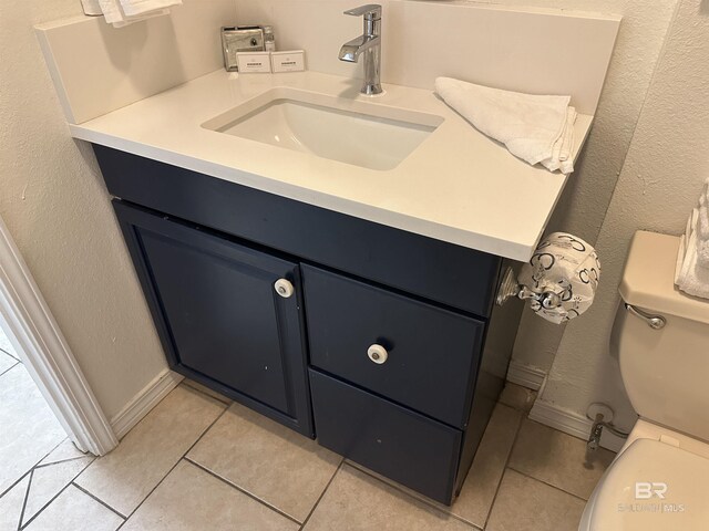 bathroom with vanity, toilet, and tile floors