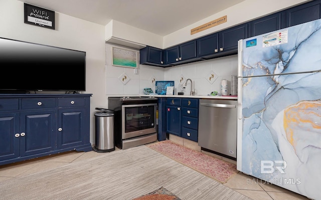 kitchen featuring white refrigerator, sink, tasteful backsplash, dishwasher, and blue cabinets