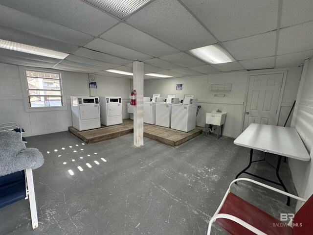 basement with sink, washing machine and dryer, and a paneled ceiling