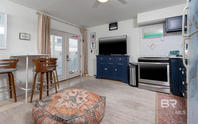 kitchen with french doors, stainless steel stove, a breakfast bar area, ceiling fan, and blue cabinets