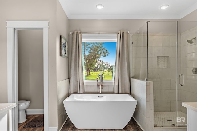 bathroom with hardwood / wood-style floors, toilet, and shower with separate bathtub