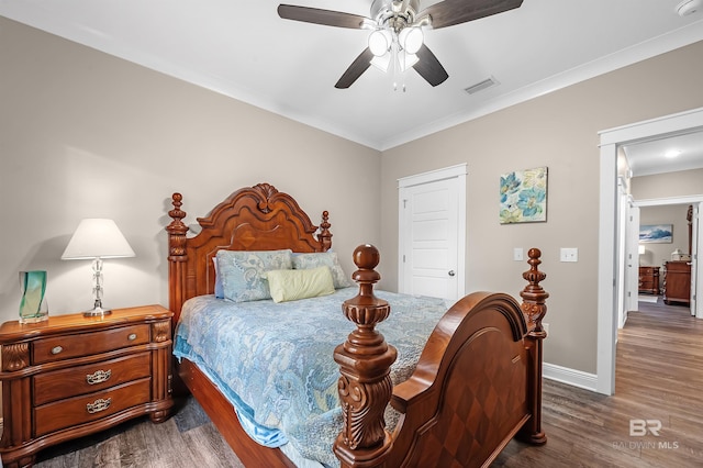 bedroom featuring ceiling fan, crown molding, and dark wood-type flooring