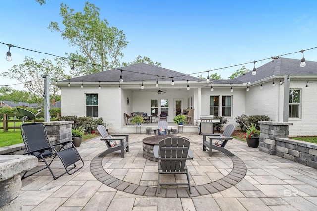 view of patio with ceiling fan and an outdoor fire pit