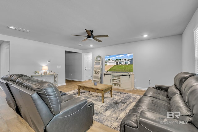 living room featuring ceiling fan and light wood-type flooring