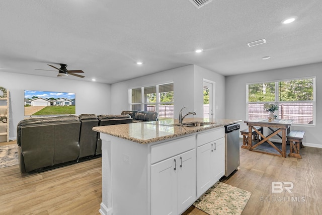 kitchen featuring ceiling fan, a kitchen island with sink, sink, light wood-type flooring, and white cabinets