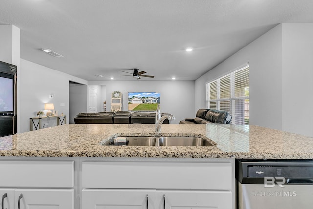 kitchen with stainless steel dishwasher, light stone countertops, ceiling fan, and sink