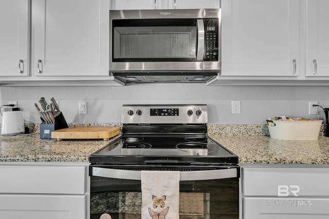 kitchen with stainless steel appliances, white cabinets, and light stone countertops