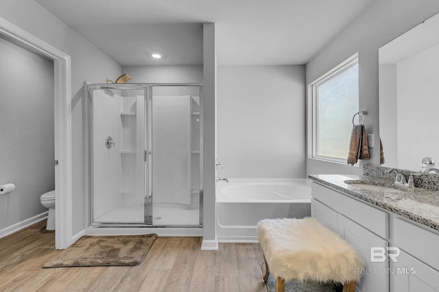 full bathroom with vanity, independent shower and bath, hardwood / wood-style floors, and toilet