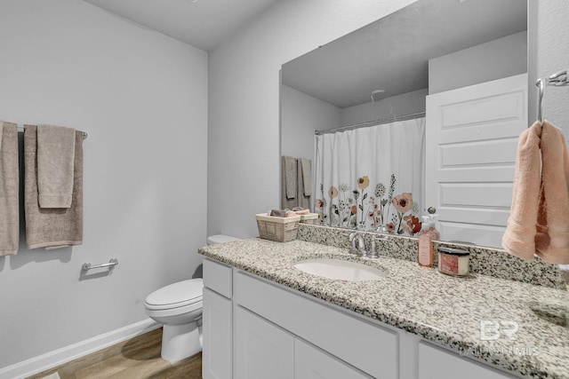 bathroom featuring hardwood / wood-style floors, vanity with extensive cabinet space, and toilet