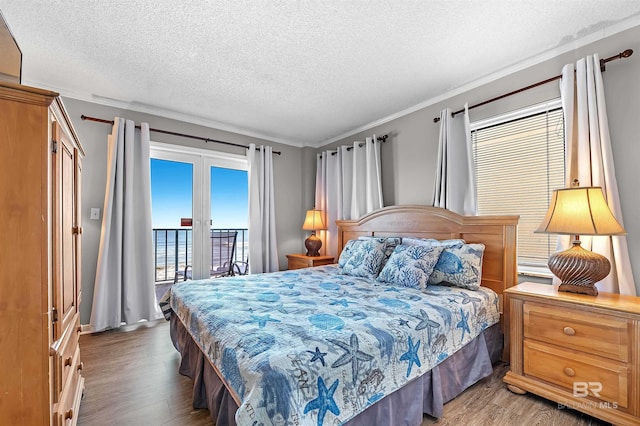 bedroom featuring crown molding, access to outside, wood finished floors, and a textured ceiling