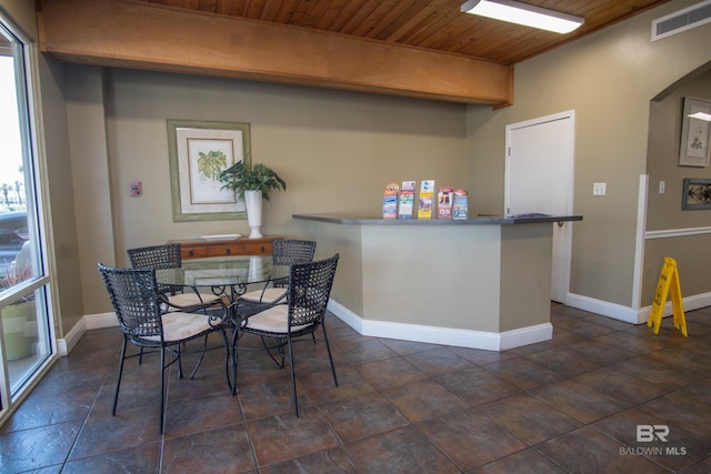 dining space featuring wood ceiling, baseboards, visible vents, and arched walkways