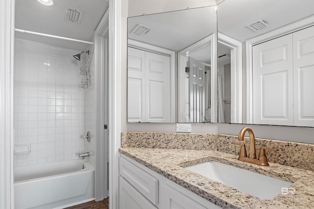 bathroom featuring vanity, visible vents, and shower / bathing tub combination