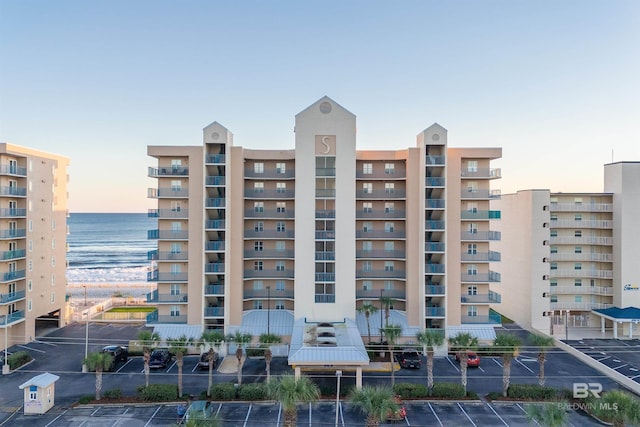 view of building exterior featuring uncovered parking and a water view
