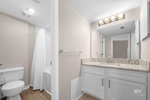 full bathroom featuring toilet, vanity, wood finished floors, and visible vents