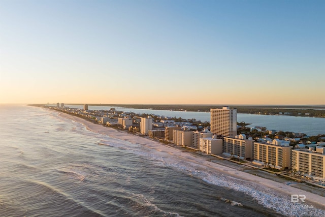 aerial view at dusk with a beach view and a water view