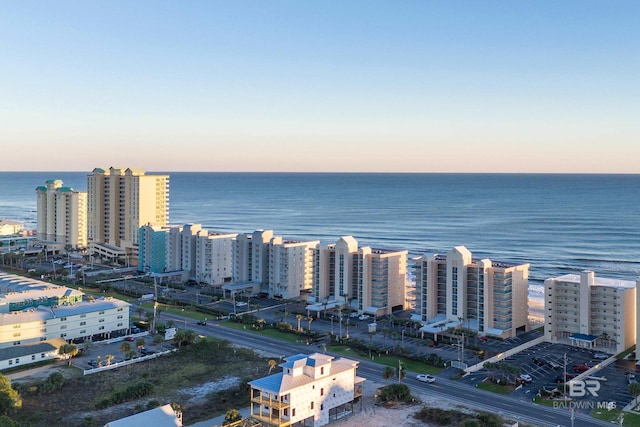 aerial view at dusk featuring a water view and a view of city