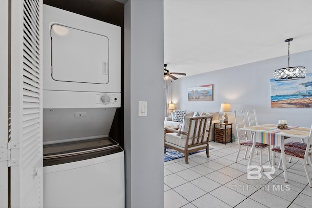 laundry area featuring stacked washing maching and dryer, ceiling fan, and light tile patterned floors