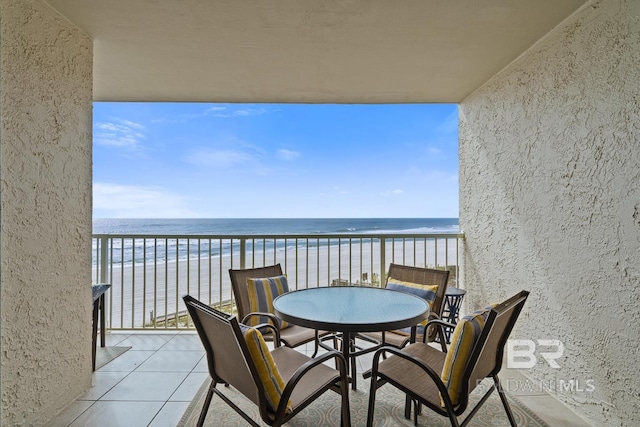 balcony with a water view and a view of the beach