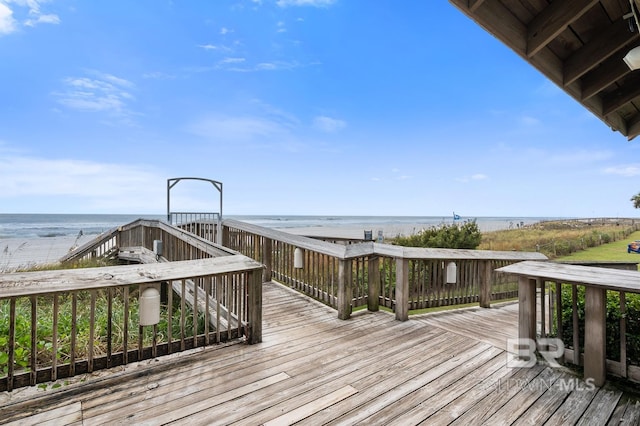 wooden deck with a water view and a view of the beach