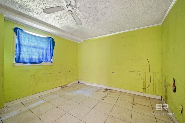 tiled spare room with a textured ceiling, ceiling fan, and ornamental molding