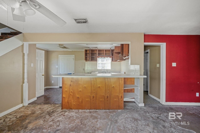 kitchen with dark tile patterned floors, a breakfast bar, sink, decorative backsplash, and ceiling fan