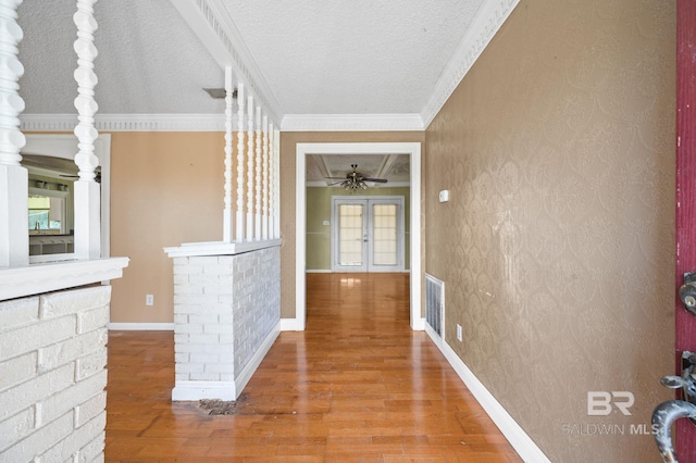 hallway featuring a textured ceiling, crown molding, and hardwood / wood-style floors