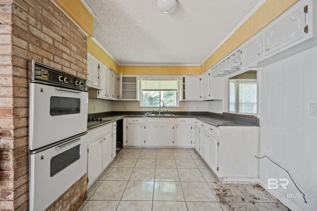 kitchen featuring sink, white cabinetry, and light tile patterned floors