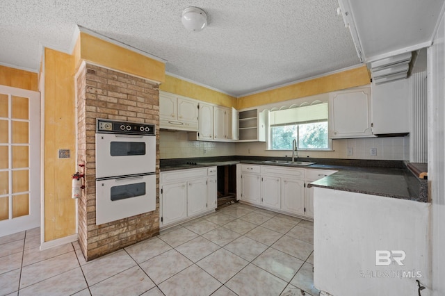 kitchen with decorative backsplash, light tile patterned floors, sink, and white double oven