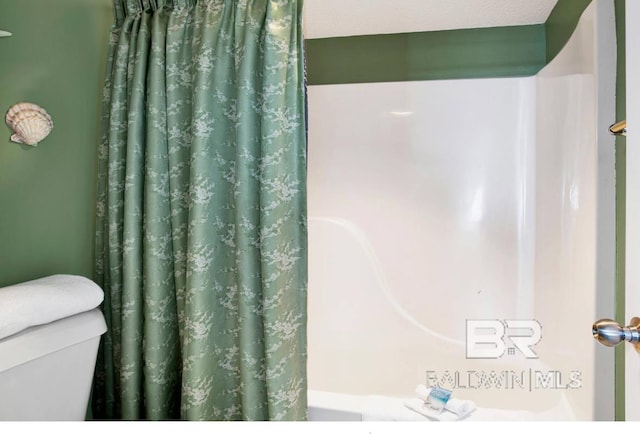 full bath featuring toilet and a shower with curtain