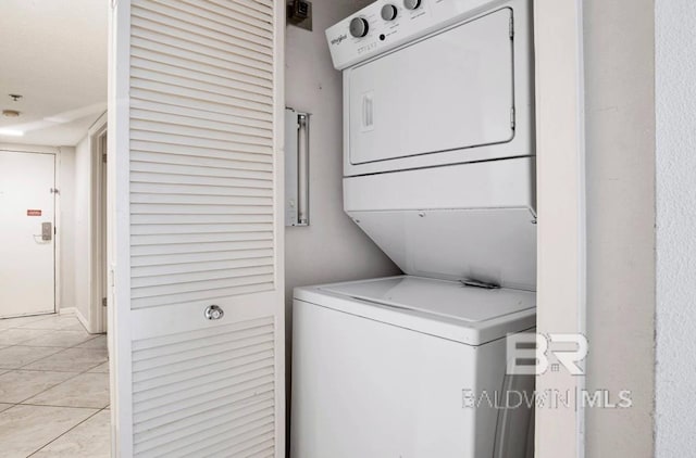 laundry area with laundry area, light tile patterned flooring, and stacked washer and clothes dryer