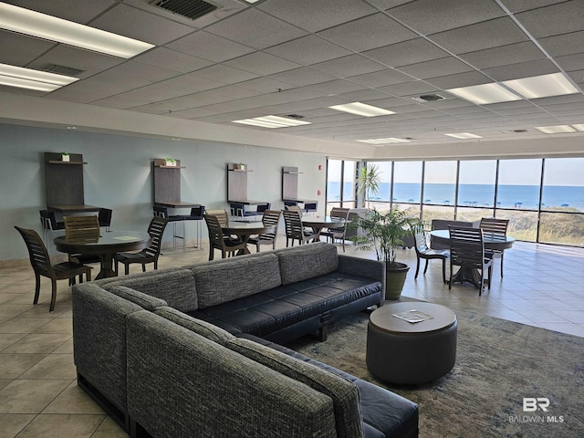 living area with tile patterned floors, visible vents, and a paneled ceiling