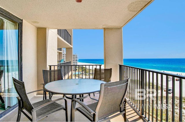 balcony with a beach view and a water view
