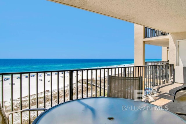 balcony featuring a beach view and a water view