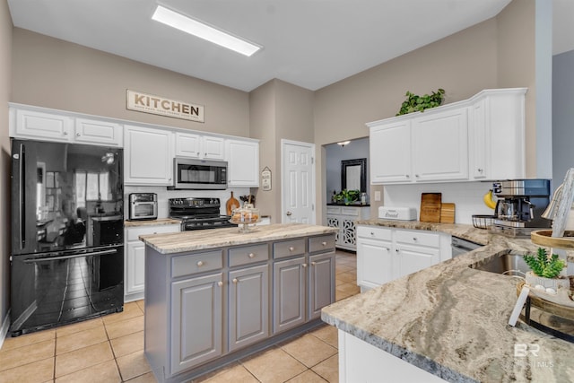 25697 Overlook Dr, Loxley, AL 36551 - kitchen featuring black appliances, white cabinets, light tile patterned flooring, gray cabinetry, and light stone counters