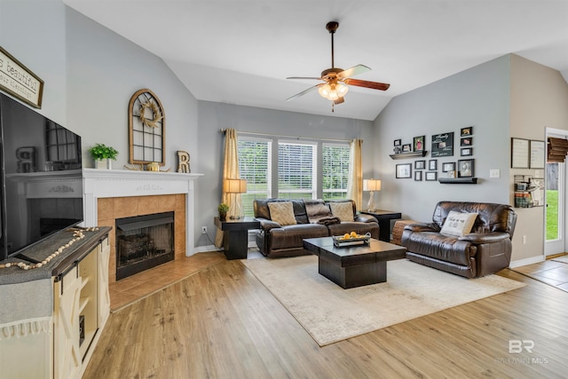 25697 Overlook Dr, Loxley, AL 36551 - living area with a tiled fireplace, vaulted ceiling, a ceiling fan, light wood-style flooring, and baseboards