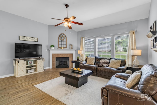 25697 Overlook Dr, Loxley, AL 36551 - living room featuring wood finished floors, ceiling fan, a tile fireplace, baseboards, and vaulted ceiling